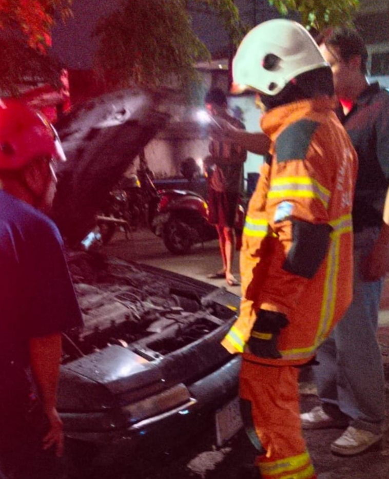 HANGUS : Petugas DPKP Surabaya melakukan pengecekan mobil Mazda Astina milik Dermawan yang terbakar di Jalan Jemur Andayani Surabaya, Sabtu malam (25/10).(IST/RADAR SURABAYA)