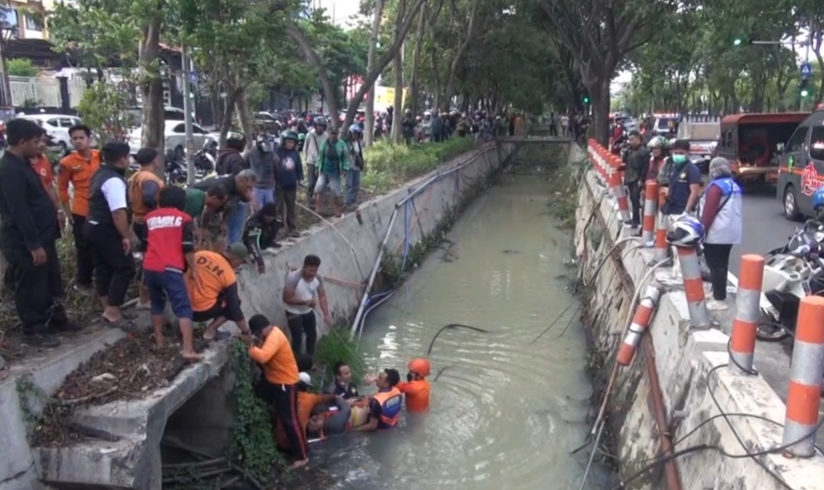 DRAMATIS : Petugas gabungan mengevakuasi M Mustofa korban kecelakaan tercebur sungai di Jalan Ahmad Yani, Surabaya, Selasa (28/10).(IST/RADAR SURABAYA)