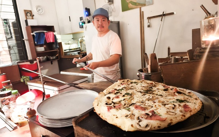 METODE TRADISIONAL: Irwan, pemilik Salomon Pizzeria, menyiapkan pizza khas Italia yang dimasak dengan menggunakan metode tradisional memakai tungku, di kawasan Petemon, Surabaya, Jumat (31/10).