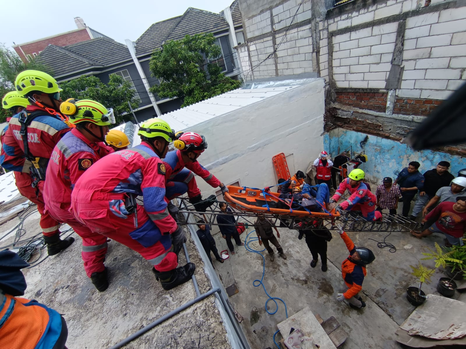 SELAMAT : Tim Rescue DPKP Surabaya bersama warga mengevakuasi Abi Maruf Ramadhani yang tersengat kabel listrik di atap rumah warga Jalan Jojoran I, Surabaya, Sabtu (8/11).(IST/RADAR SURABAYA)