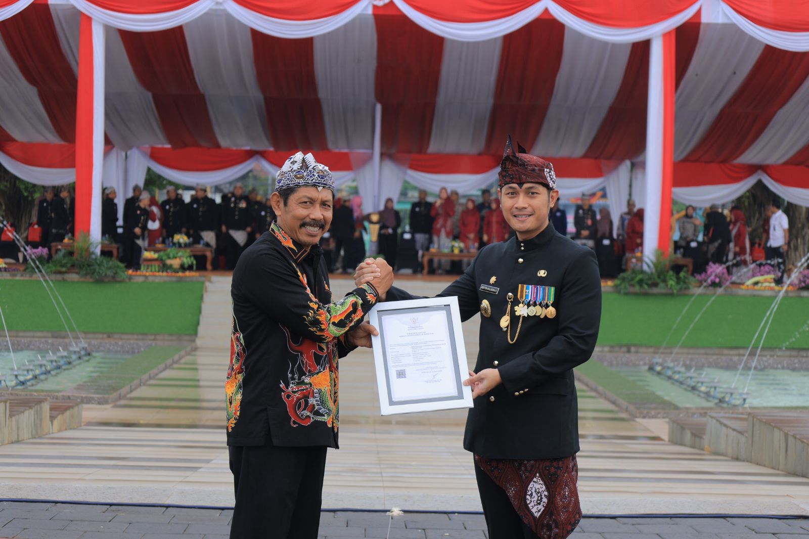 APRESIASI: Kakanwil Kemenkum Jatim&nbsp;Haris Sukamto (kiri)&nbsp;menyerahkan Sertifikat Indikasi Geografis (IG) Batik Tulis Tenun Gedhog Tuban kepada Bupati Tuban, Aditya Halindra Faridzky.&nbsp;