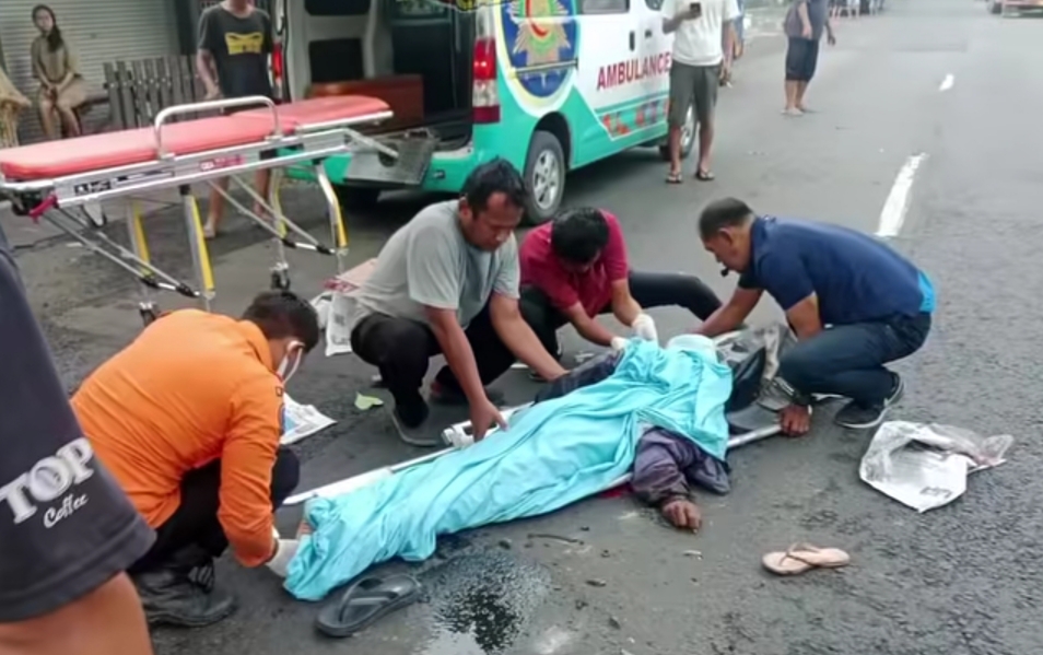 LUKA PARAH: Petugas saat mengevakuasi kecelakaan sepeda motor dengan truk di Jalan Mastrip, Surabaya. (IST/RADAR SURABAYA)