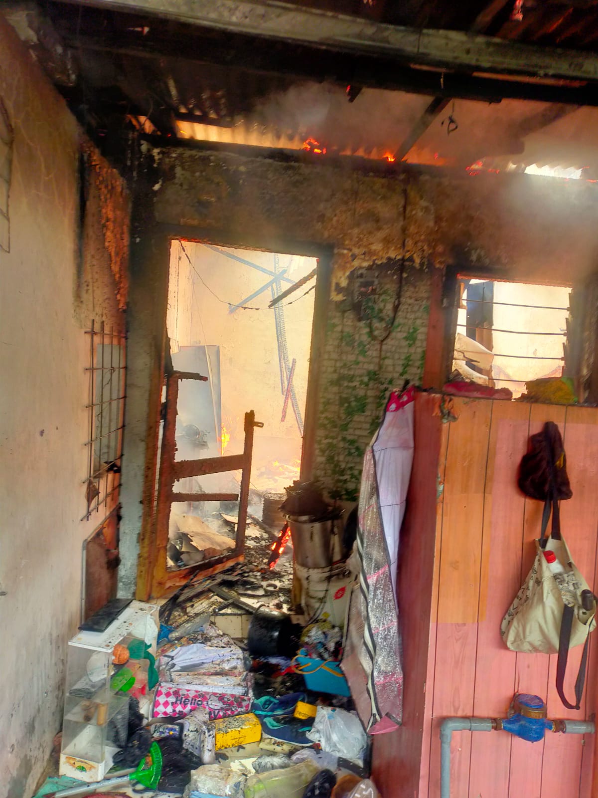 PEMBASAHAN : Rumah milik M Ashop warga Jalan Jangkungan II, Surabaya, terbakar, Senin (1/12). Diduga penyebab rumah terbakar karena korsleting listrik. (IST/RADAR SURABAYA)