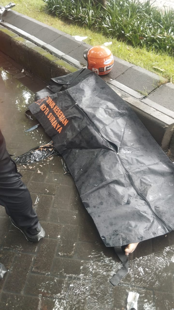 SEBELUM DIEVAKUASI: Jasad korban pengendara motor yang meninggal dunia usai tabrak pembatas jalan di Jalan Rungkut Industri, Surabaya. (IST/RADAR SURABAYA)