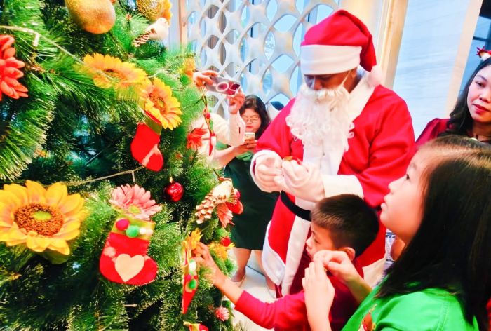 DEKORASI NATAL: Sejumlah anak penyandang disabilitas, membuat kreasi dekorasi untuk pohon Natal dengan memanfaatkan kain bekas sprei hotel sebagai bahan utamanya, di Hotel Ciputra World Surabaya.