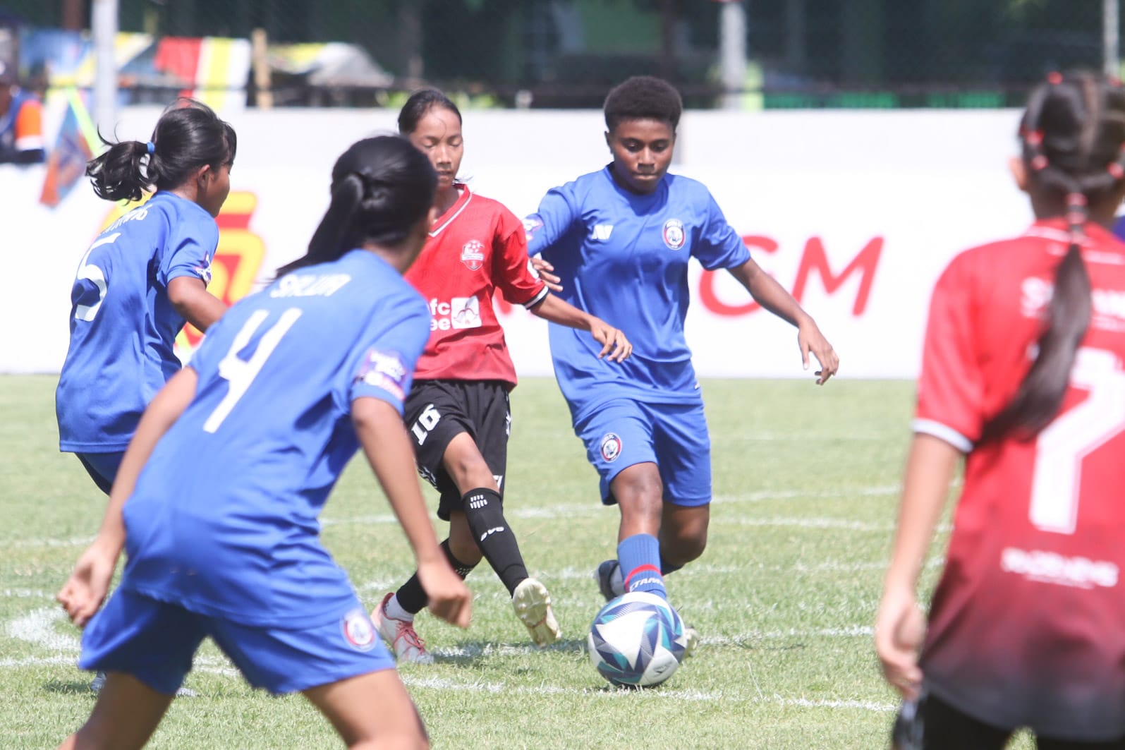 Pemain Arema FC Women (biru) berusaha melewati hadangan pemain Srikandi Mojopahit FC dalam lanjutan Liga Sepak Bola Putri U-15 di Lapangan Bogowonto, Surabaya.