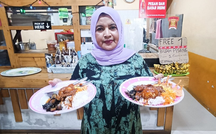 KULINER LEGENDARIS: Jumaatun menunjukkan menu makanan nasi cumi yang sudah memasuki generasi ketiga, yang berada di kawasan Pasar Atom, Surabaya, Senin (8/12).