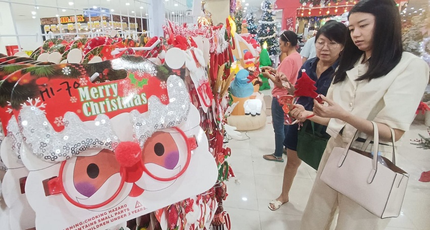 BERBURU AKSESORIS: Sejumlah pengunjung memilih aksesoris untuk perayaan Natal 2025, di Sentosa Florist, Pasar Atom Mall, Surabaya, Senin (8/12).