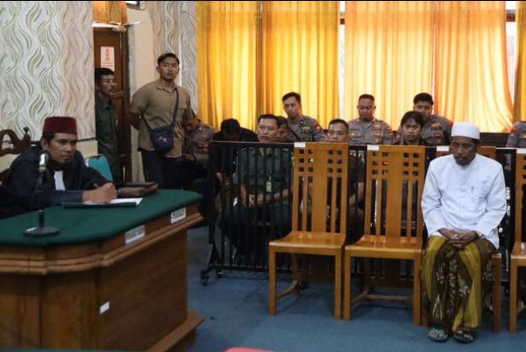 M Sahnan, pengurus pondok pesantren di Sumenep yang menjadi terdakwa pemerkosa 8 santriwatinya saat menjalani sidang di PN Sumenep.