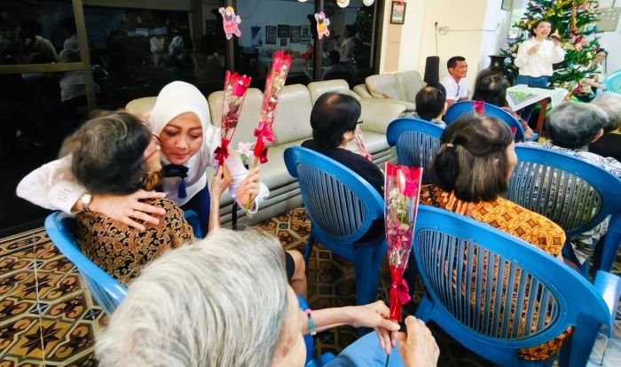 BERBAGI: Sejumlah anggota Rotary Club Surabaya Kaliasin, memberikan bunga mawar merah kepada para penghuni Panti Werdha Usia, Undaan, sebagai bentuk berbagi kasih jelang perayaan Natal 2025