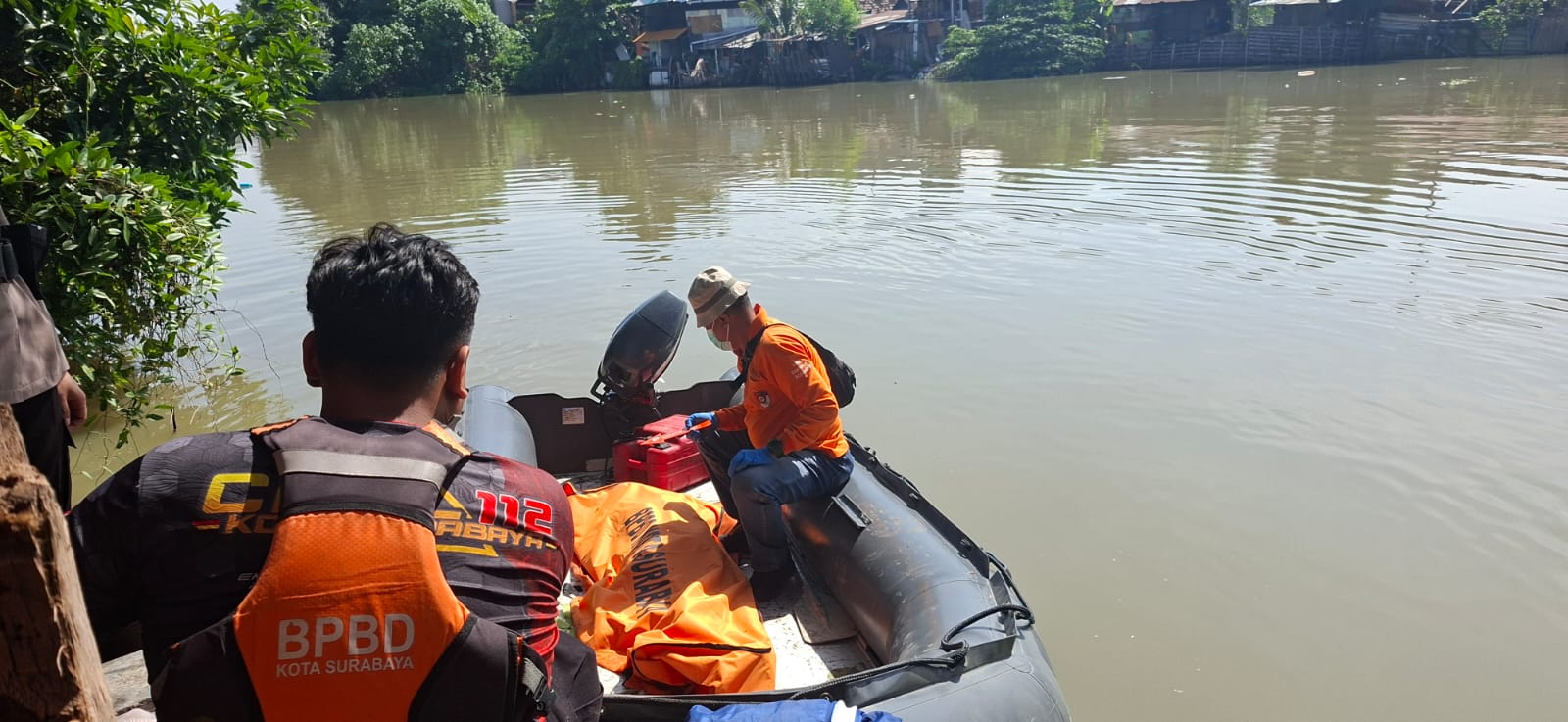 DIEVAKUASI: Petugas BPBD Surabaya mengevakuasi jasad pria yang tenggelam di sungai kawasan Jalan Gunungsari, Surabaya. (MAHRUS/RADAR SURABAYA)