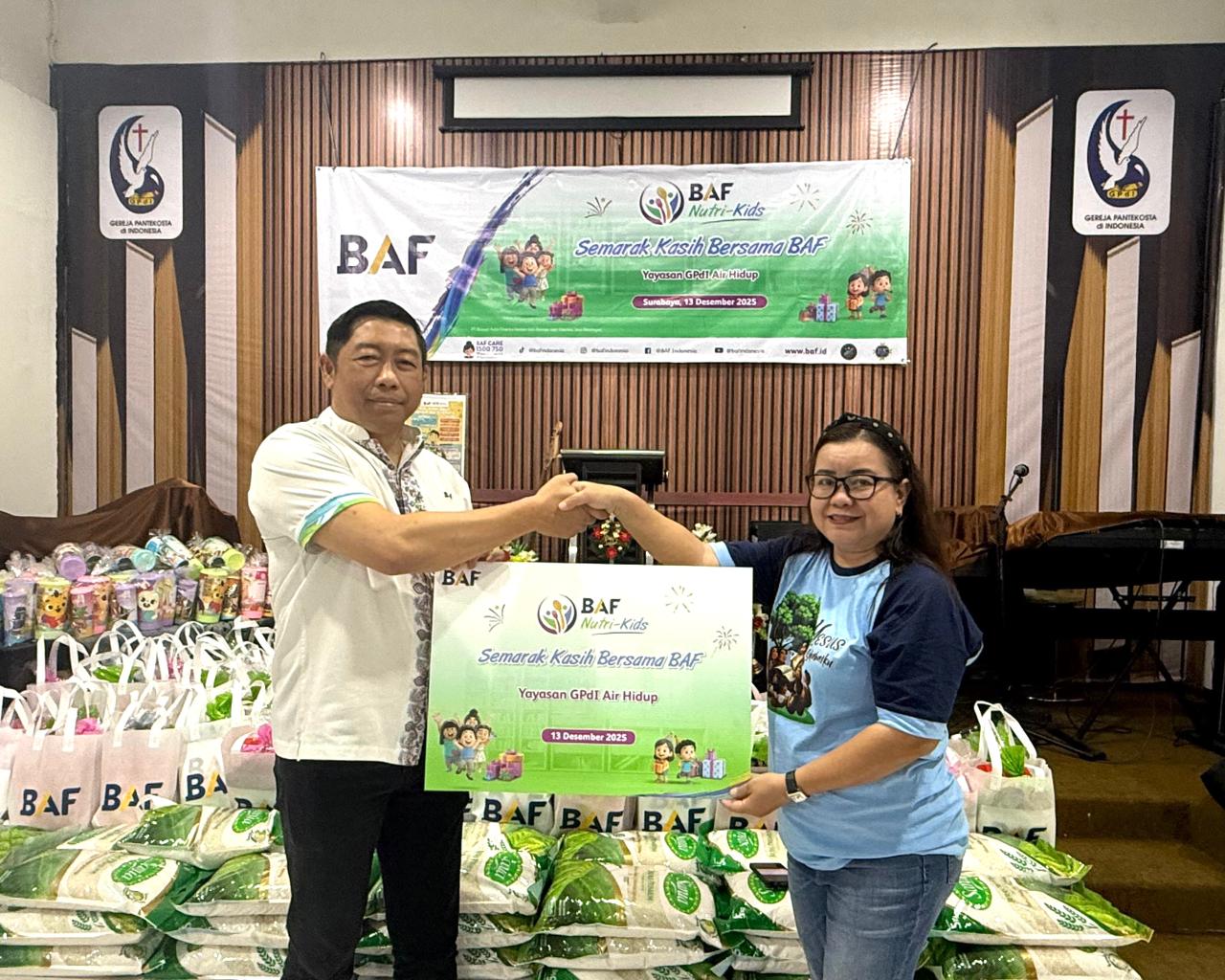 Regional Center Head BAF Surabaya, Novie Suharto menyerahkan simbolis bingkisan akhir tahun kepada Vira Valianti dalam CSR BAF Nutri-Kids