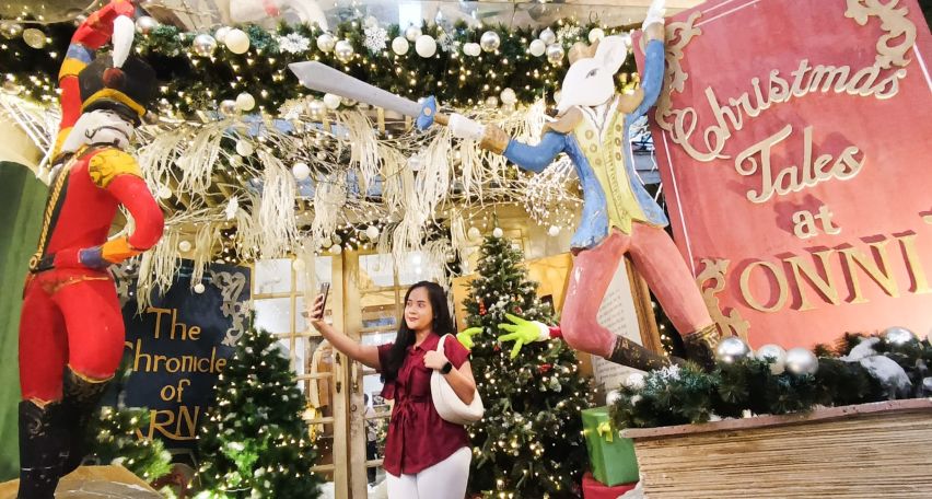DEKORASI DONGENG: Pengunjung berfoto dengan latar belakang dekorasi Nutcracker, yang dipasang sebelum pintu masuk Onni House Surabaya, Jumat (12/12).