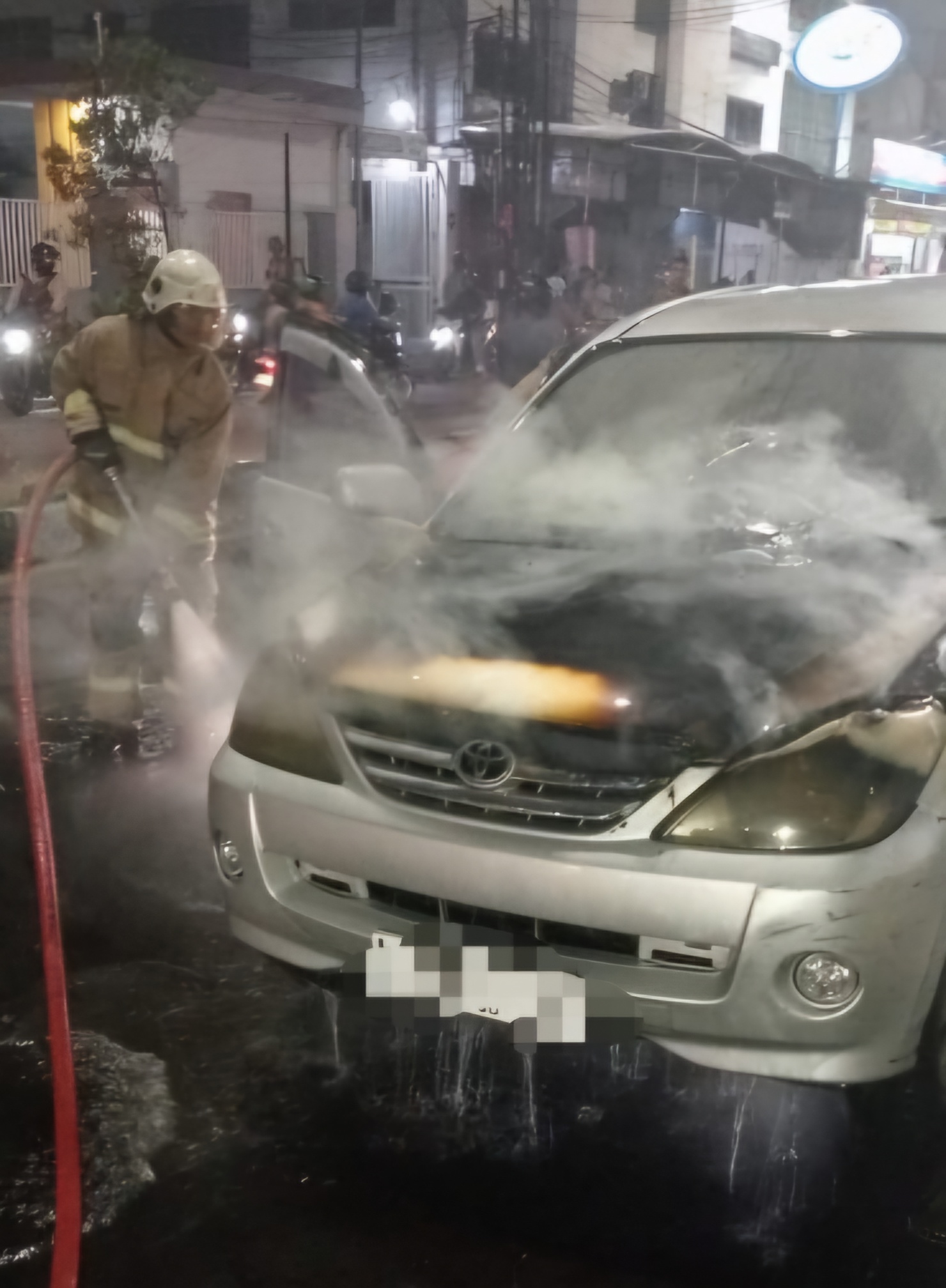 SIGAP : Petugas DPKP Surabaya berupaya memadamkan dan melakukan pembasahan terhadap mobil yang terbakar di Jalan Kapasari, Surabaya Kamis (18/12) malam.(IST/RADAR SURABAYA)