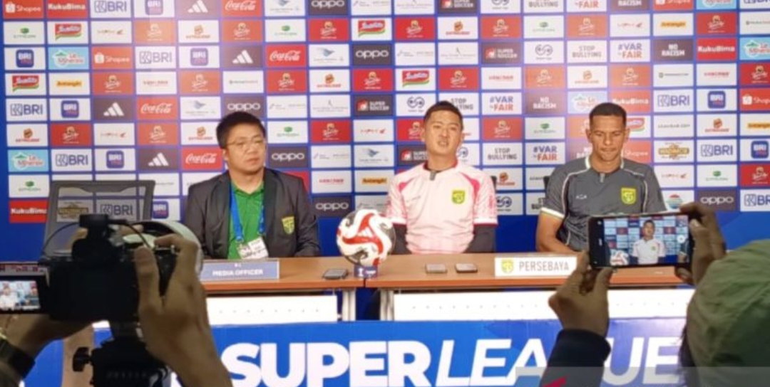 Pelatih fisik Persebaya Shin Sang-gyu (tengah) bersama pemainnya Leo Lelis (kanan) saat konferensi pers di Stadion GBT Surabaya, Jumat (19/12/2025).