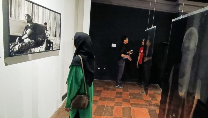 ANAK PEKERJA MIGRAN: Pengunjung mengamati foto karya fotografer dokumenter, Romi Perbawa yang mengangkat kehidupan anak-anak dari pekerja migran, di Galeri Dewan Kesenian Surabaya (DKS), Jumat (19/12)