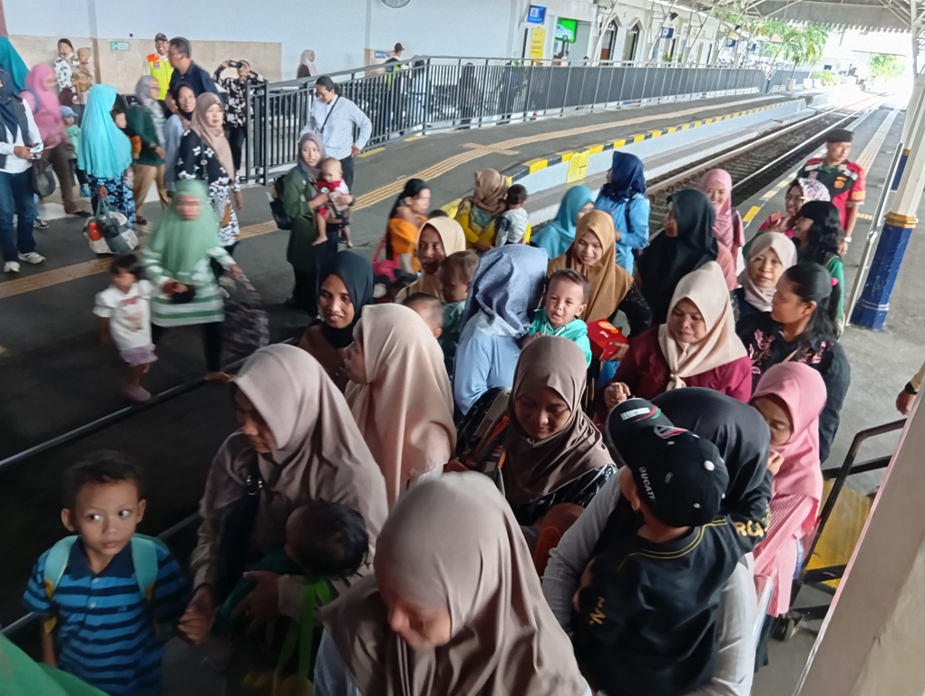 Rini Indriyani bersama anak-anak dan orang tua di stasiun Surabaya   Gubeng lama untuk mengenalkan kereta api commuter line. (Rahmat Sudrajat/Radar Surabaya)