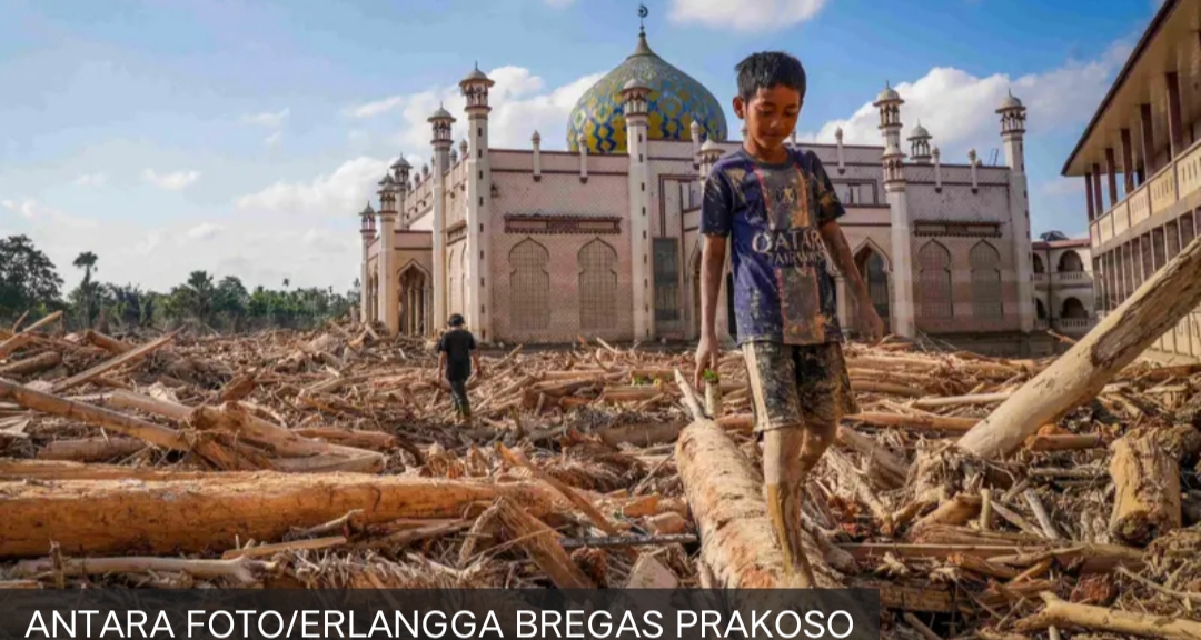 Seorang bocah berjalan meniti kayu-kayu yang memenuhi area Pondok Pesantren Darul Mukhlishin pascabanjir bandang di Desa Tanjung Karang, Karang Baru, Kabupaten Aceh Tamiang, Aceh, Jumat (5/12).