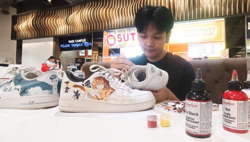 KREASI SEPATU: Fernaldy menunjukkan kreasi sepatu lukis orderan pelanggannya, dengan berbagai macam gambar mulai dari Anime hingga tulisan biasa.