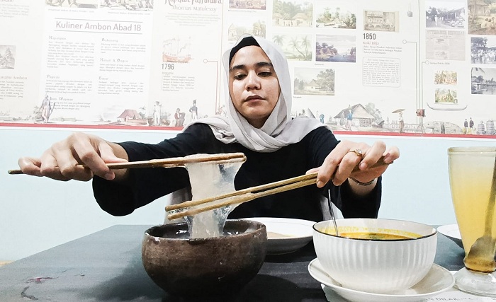 UNIK: Seorang pengunjung keturunan Ambon, menunjukkan cara menikmati papeda (inset) dengan menggunakan gata-gata, di rumah makan Maluku Surabaya, Minggu (28/12).