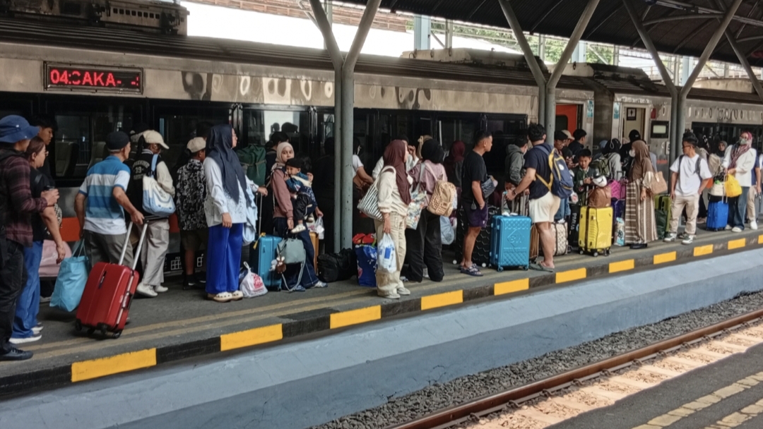 Penumpang menggunakan transportasi kereta api untuk libur panjang tahun baru di Stasiun Surabaya Gubeng.