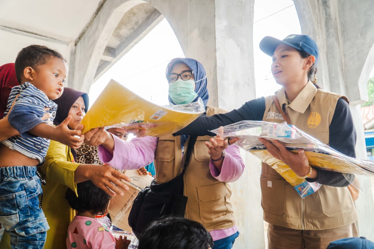 PEDULI: Tim dokter Fakultas Kedokteran Unesa memberikan pelayanan kesehatan bagi masyarakat terdampak banjir,  terutama bagi anak-anaka. Sementara tim psikolog melakukan pendampingan psikososial.