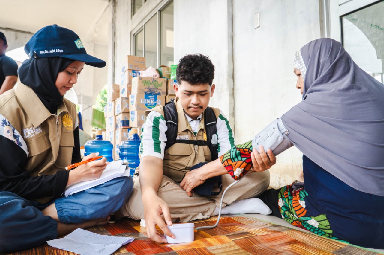 CEK KESEHATAN: Tim dari Fakultas Kedokteran (FK) Unesa memberikan pelayanan kesehatan kepada warga di posko layanan kesehatan kawasan Aceh Tamiang.