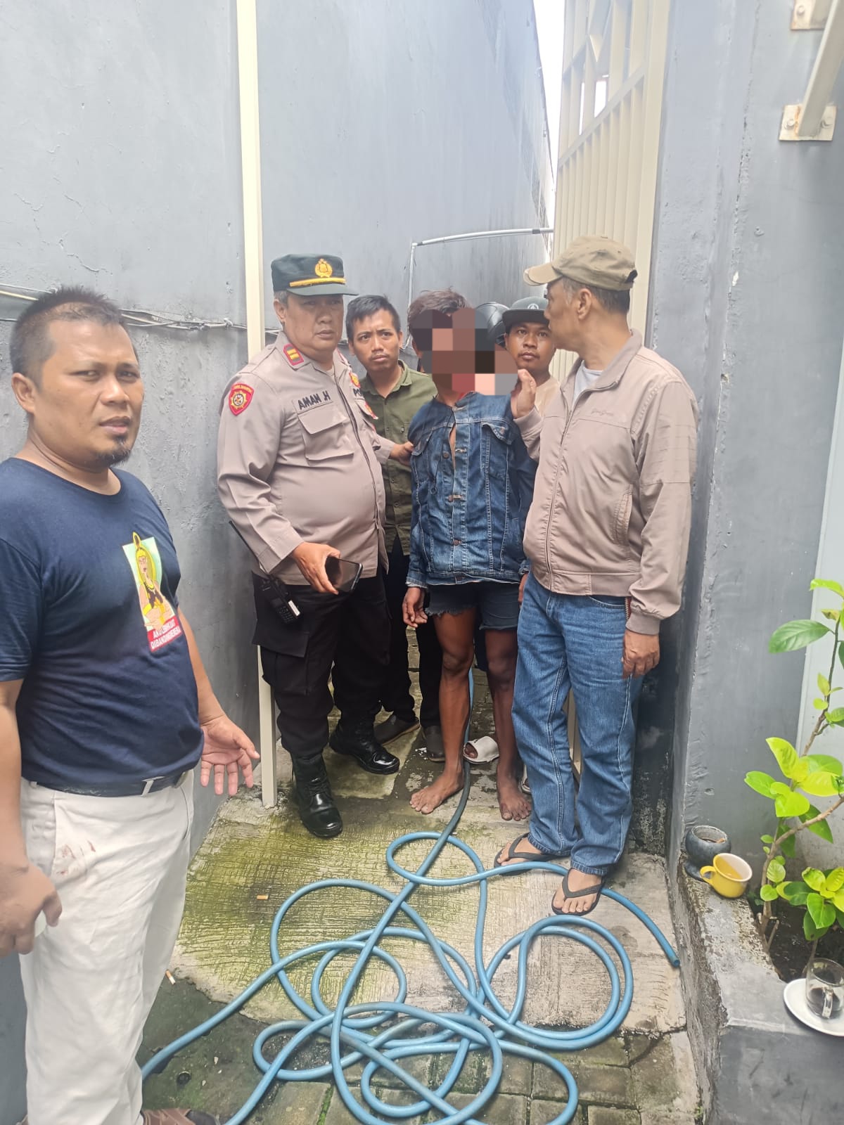DIAMANKAN : Polisi dan warga mengamankan pelaku pencuri motor yang sempat dihajar massa di Jalan Kapas Madya Baru, Surabaya.(IST/RADAR SURABAYA)