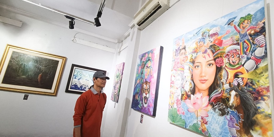 PEMBUKA TAHUN: Pengunjung mengamati karya lukis yang dipamerkan di Galeri Prabangkara, Komplek Taman Budaya Jatim, Senin (5/1).