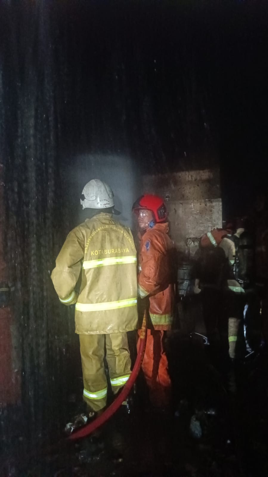 BERJIBAKU: Petugas DPKP Surabaya saat memadamkan api usai melakukan penyelamatan pada penghuni rumah. Enam orang alami luka bakar.(IST/RADAR SURABAYA)
