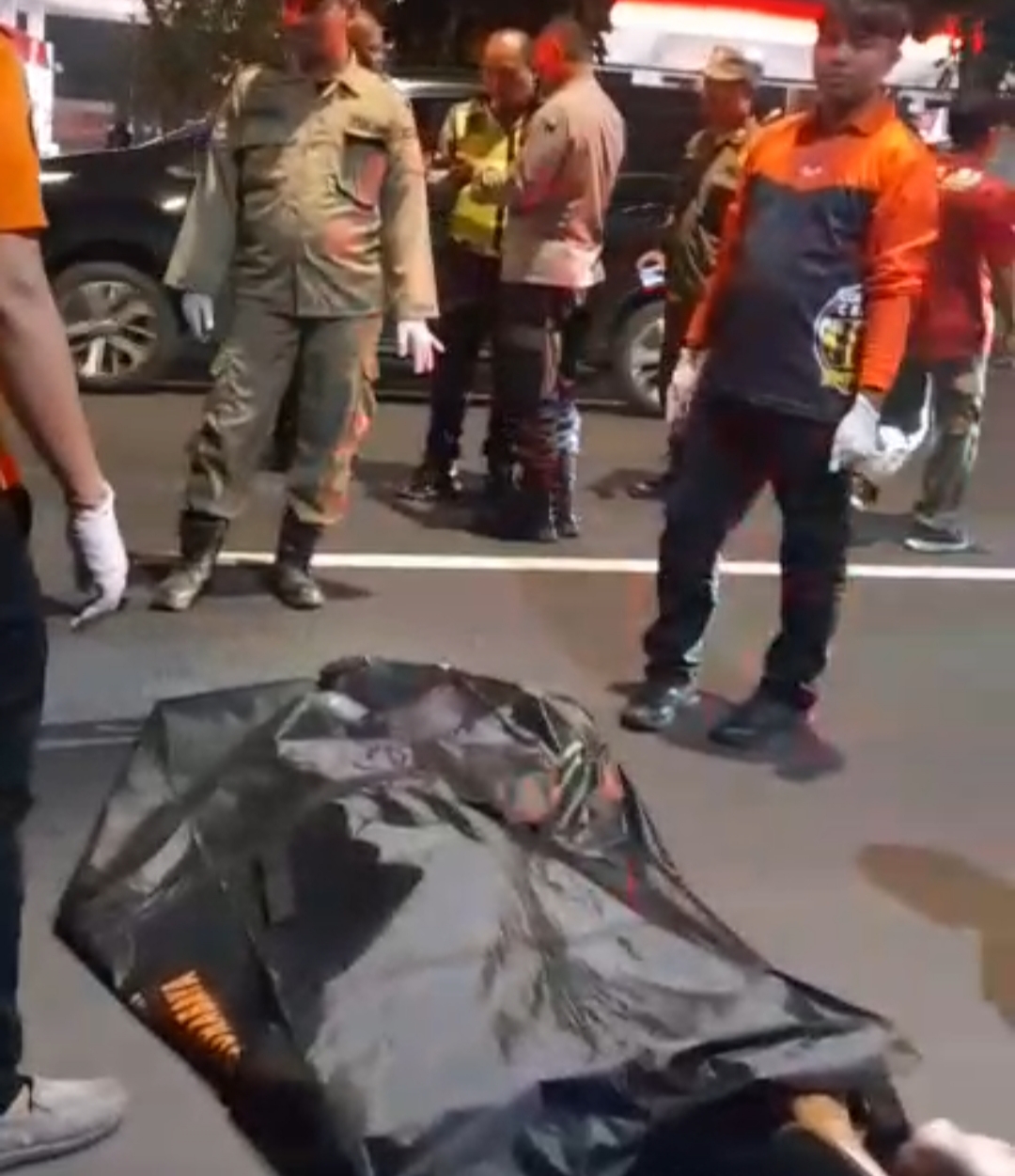 NAHAS: Korban pengendara motor saat dievakuasi petugas. Korban meninggal dunia setelah menabrak trotoar dan tiang PJU di Jalan Mayjen Sungkono, Surabaya. (IST/RADAR SURABAYA)