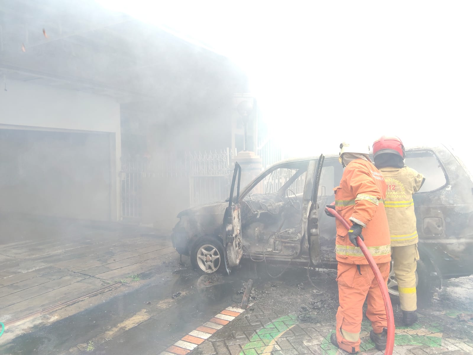 HANGUS : Petugas DPKP Surabaya saat melakukan pemadaman api yang membakar mobil Kijang milik Reyhan di Jalan Semampir Tengah II A, Surabaya, Jumat (9/1).(IST/RADAR SURABAYA)