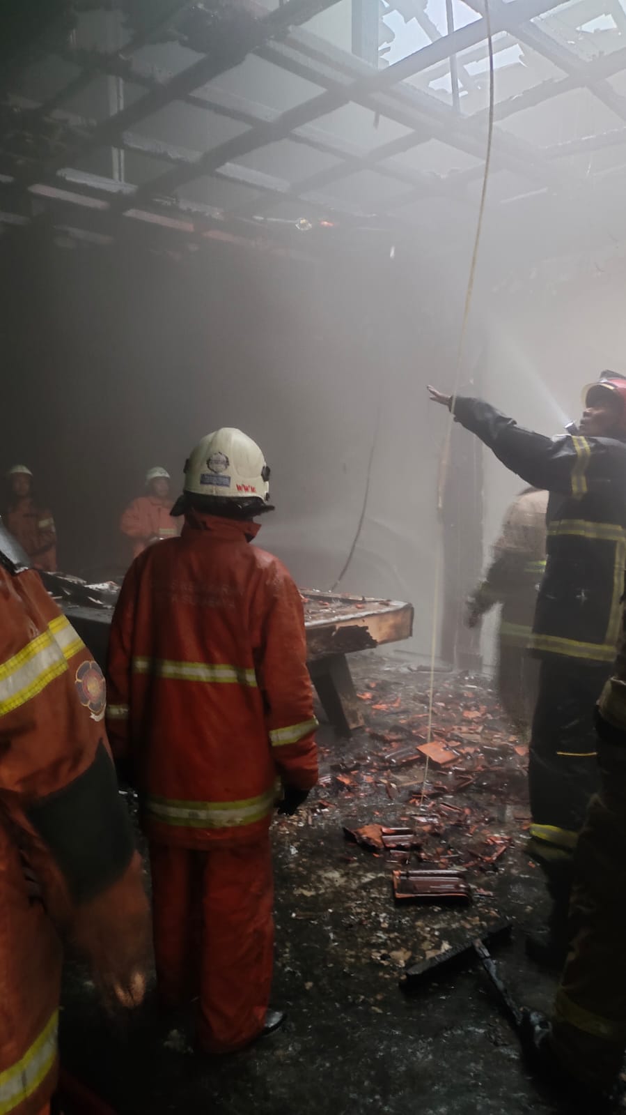 HANGUS : Petugas DPKP Surabaya melakukan pemadaman ruang tempat biliar yang terbakar di Jalan Raya Nginden, Surabaya, Senin (12/1).(IST/RADAR SURABAYA)