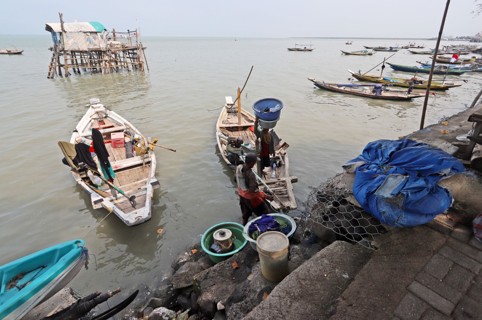 PULANG MELAUT: Semakin sedikit nelayan di Kenjeran yang mencari ikan atau kerang saat cuaca ekstrem. Beberapa di antara mereka harus berutang untuk menyambung hidup. (PUGUH SUJIATMIKO/JAWA POS)