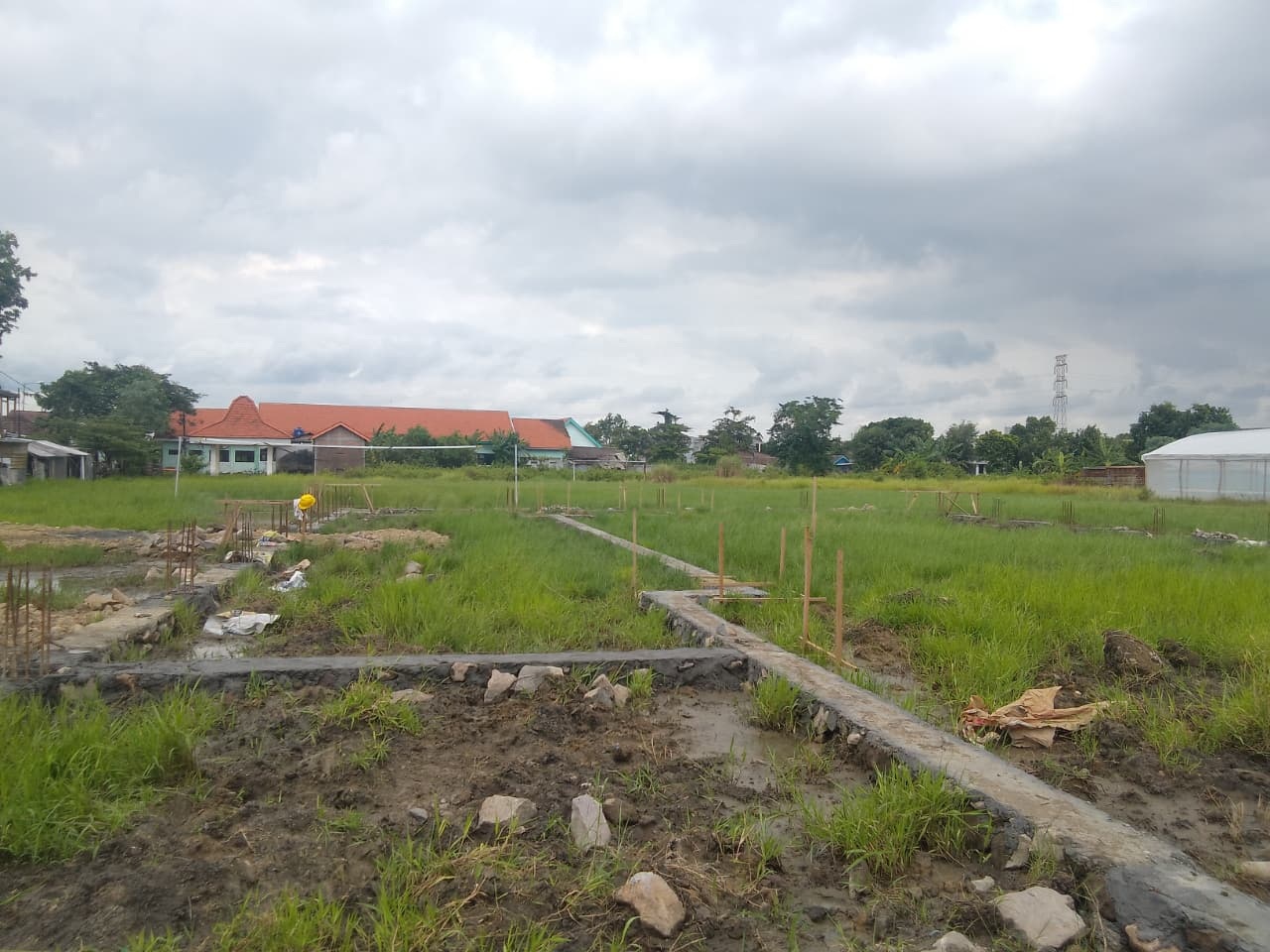 DIPROTES: Pembangunan Koperasi Desa Merah Putih (KDMP) di atas Lapangan Desa Sidorejo, Kecamatan Krian, Kabupaten Sidoarjo sudah 17 persen. (DIKY SANSIRI/RADAR SIDOARJO)