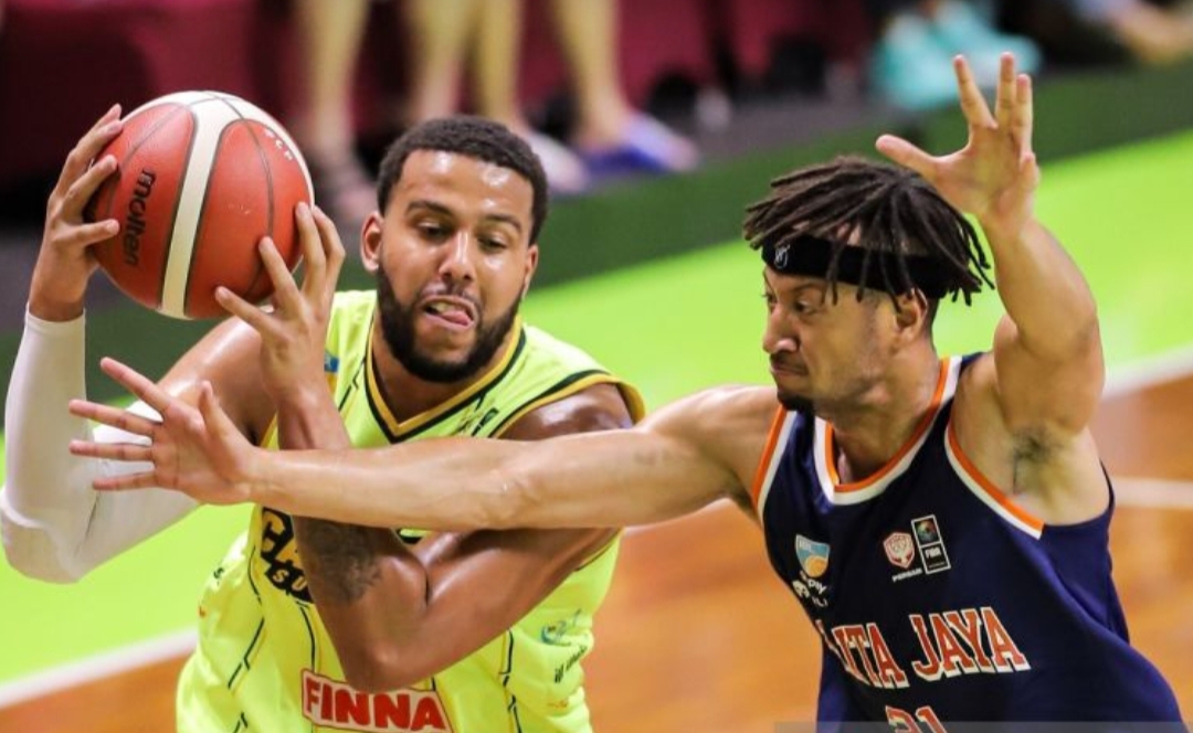 Anthony James Peacock (kiri) berusaha melewati adangan Pelita Jaya Jakarta Hendrick Xavi Yonga pada pertandingan IBL 2026 di GOR Pacific Caesar Surabaya, Jawa Timur.