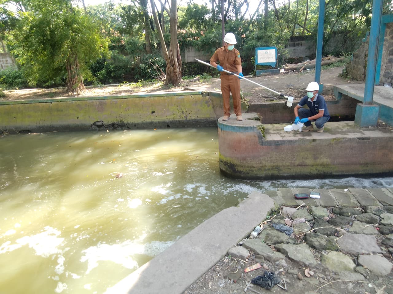 GERAK CEPAT: DLHK Kabupaten Sidoarjo turun langsung ke Sungai Dam Bono, Desa Sedati Gede, Kecamatan Sedati, menyusul kemunculan busa putih pekat disertai bau menyengat. (DIKY SANSIRI/RADAR SURABAYA)