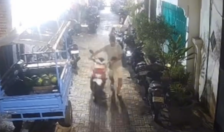 TEREKAM: Tersangka curanmor, MC saat menuntun sepeda motor korban di Jalan Gembong Sawah Barat II, Surabaya. Polisi buru penadah. (IST/RADAR SURABAYA)