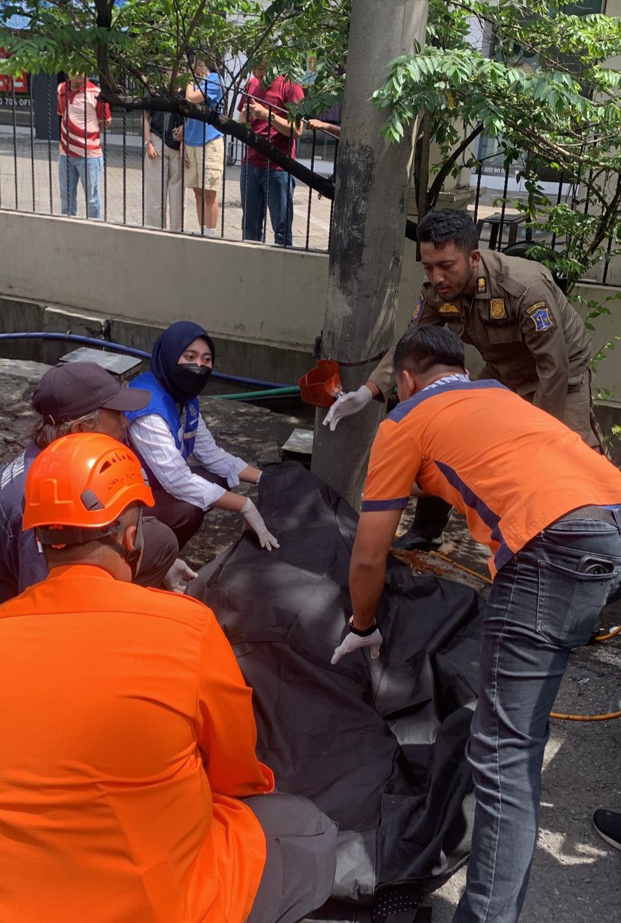 DIEVAKUASI : Petugas saat mengevakuasi jasad korban usai terlibat kecelakaan menabrak tukang tambal ban roda tiga di Jalan Diponegoro, Surabaya. (IST/RADAR SURABAYA)
