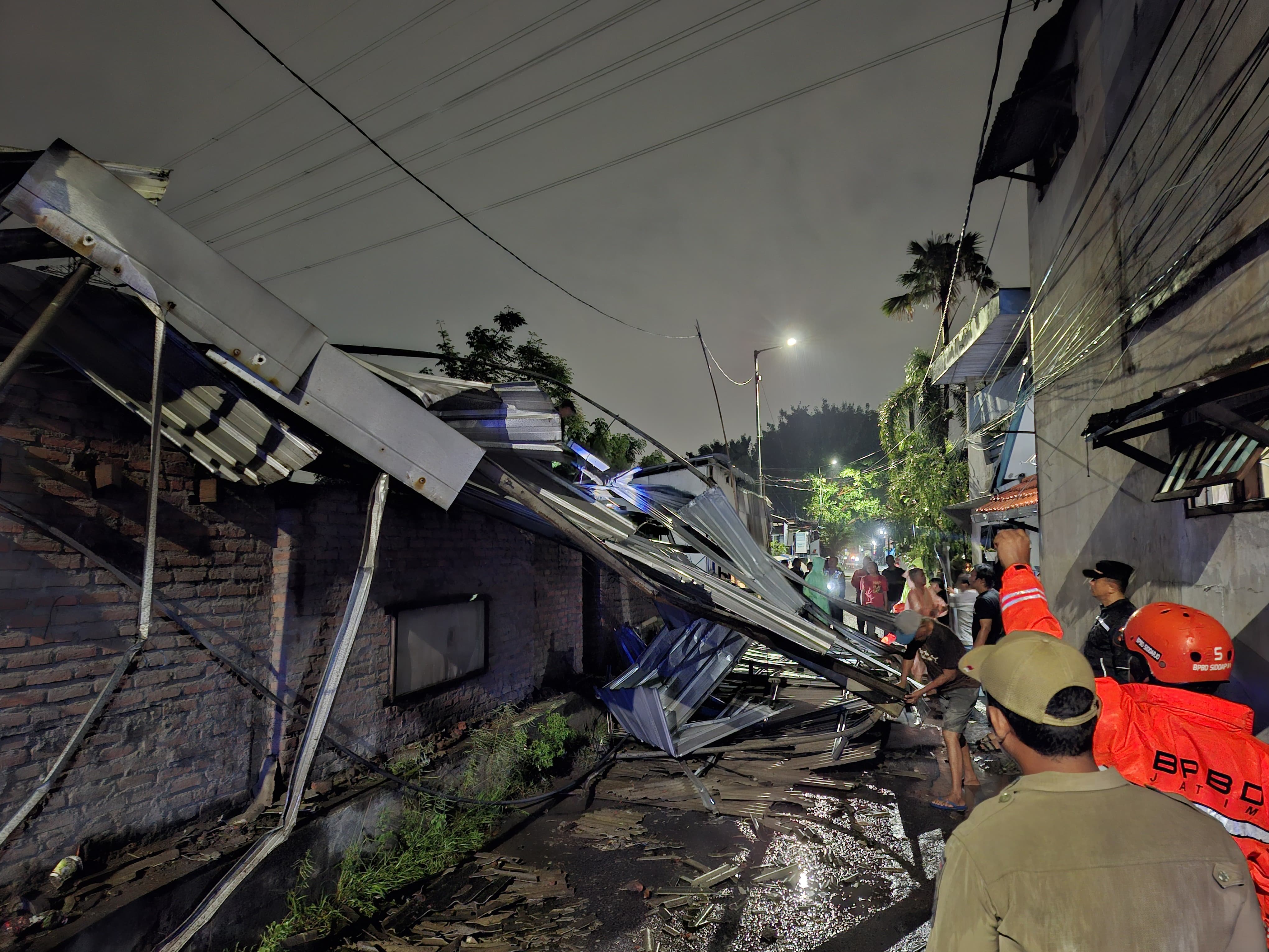 TERDAMPAK: Warga membersihkan puing-puing rumah di Sepanjang, Taman, Sidoarjo, Senin (19/1).