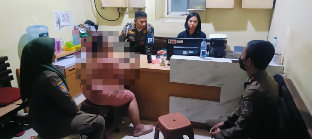 TERCIDUK: Satpol PP Kecamatan Sawahan mengamankan seorang WRSE di TPU Kembang Kuning, Surabaya.(IST/RADAR SURABAYA)