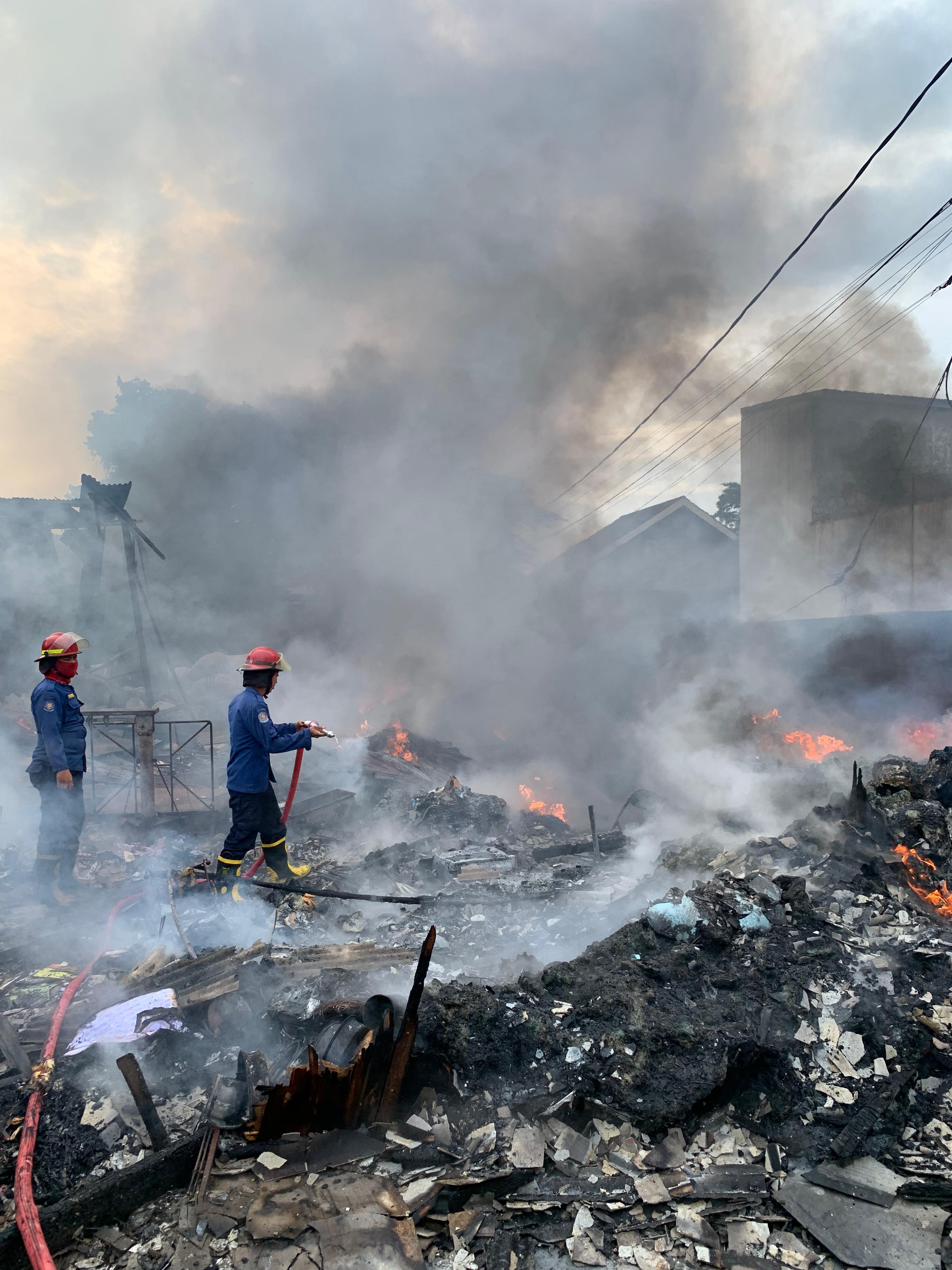 MENGEPUL: Petugas saat memadamkan kebakaran gudang rongsokan di Desa Masangan Kulon, Sukodono, Sidoarjo.(IST/RADAR SURABAYA)