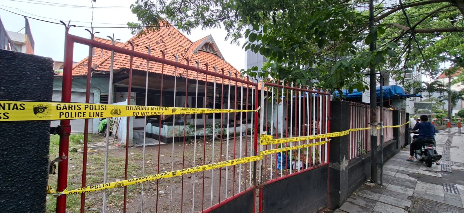 DILARANG MELINTAS: Kantor Madas ditetapkan status quo usai Satreskrim Polrestabes Surabaya memasang garis polisi di lokasi.(MAHRUS/RADAR SURABAYA)