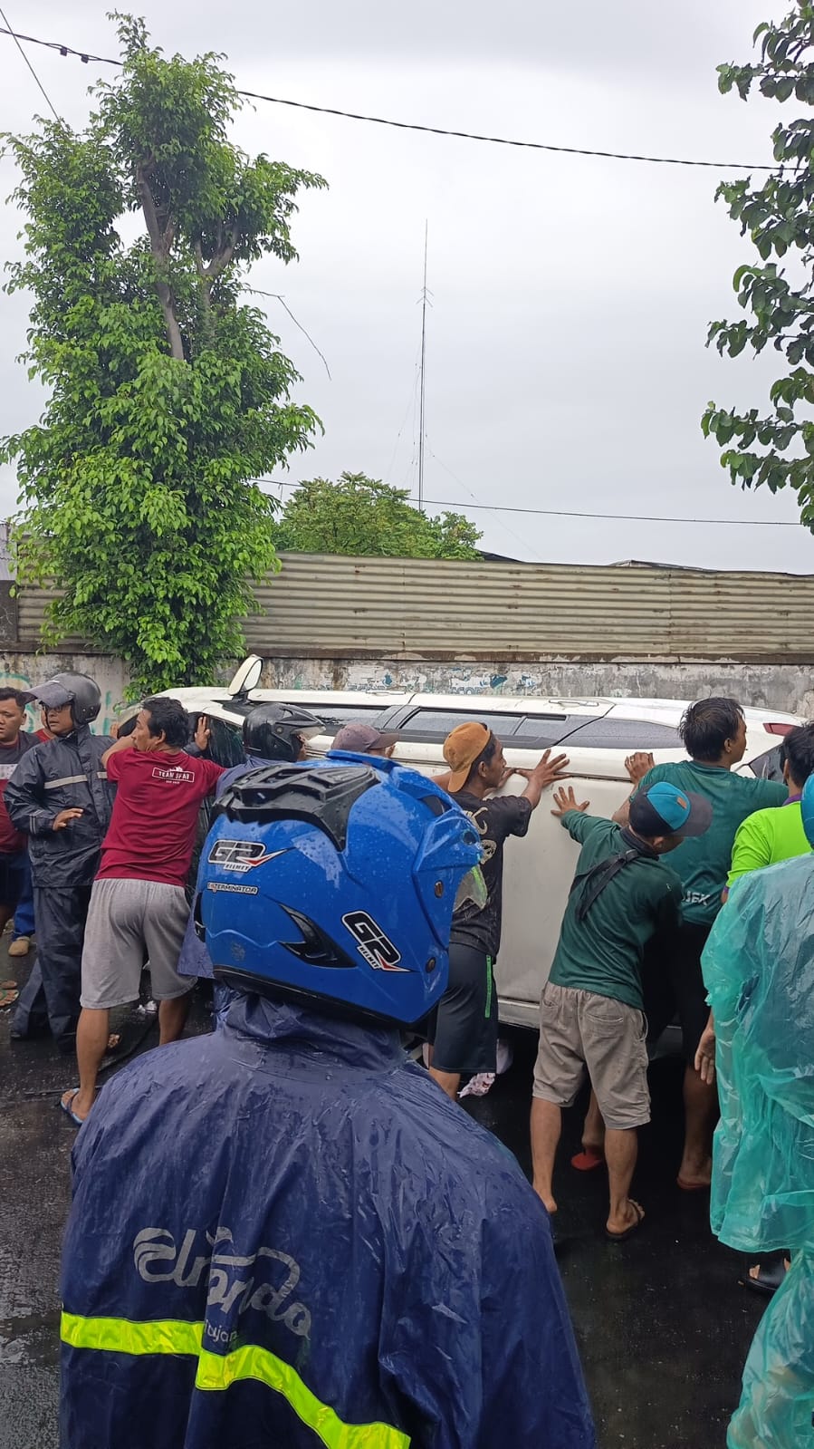 RINGSEK : Kondisi mobil MT mengalami kerusakan pada bagian depan setelah menabrak pohon dan terguling menimpa seorang pengendara motor di Jalan Pagesangan, Surabaya, Selasa (27/1).(IST/RADAR SURABAYA)