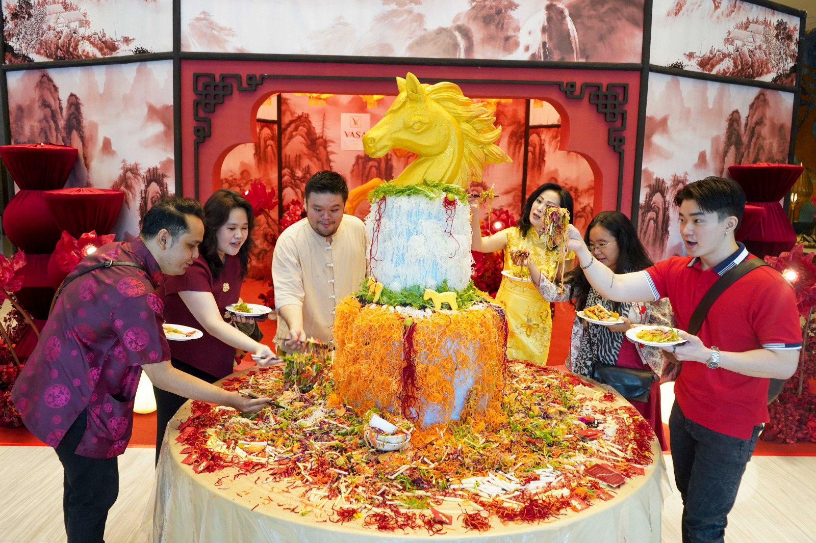 TRADISI: Tamu Vasa Surabaya di depan yee sang berukuran besar yang menjadi simbol kemakmuran, kebersamaan, dan harapan baik untuk tahun baru.