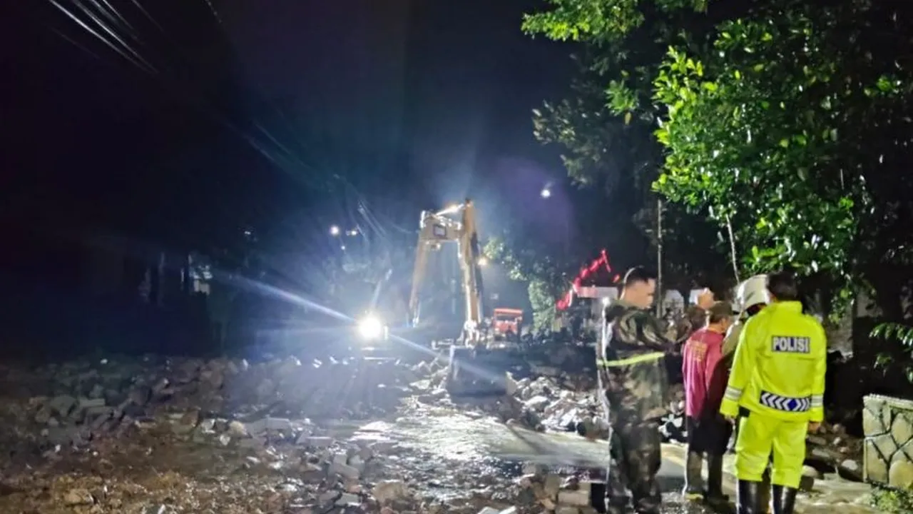 Tim dari BPBD Trenggalek membersihkan material longsor yang menutup jalur Bandung-Prigi, Desa Watulim.