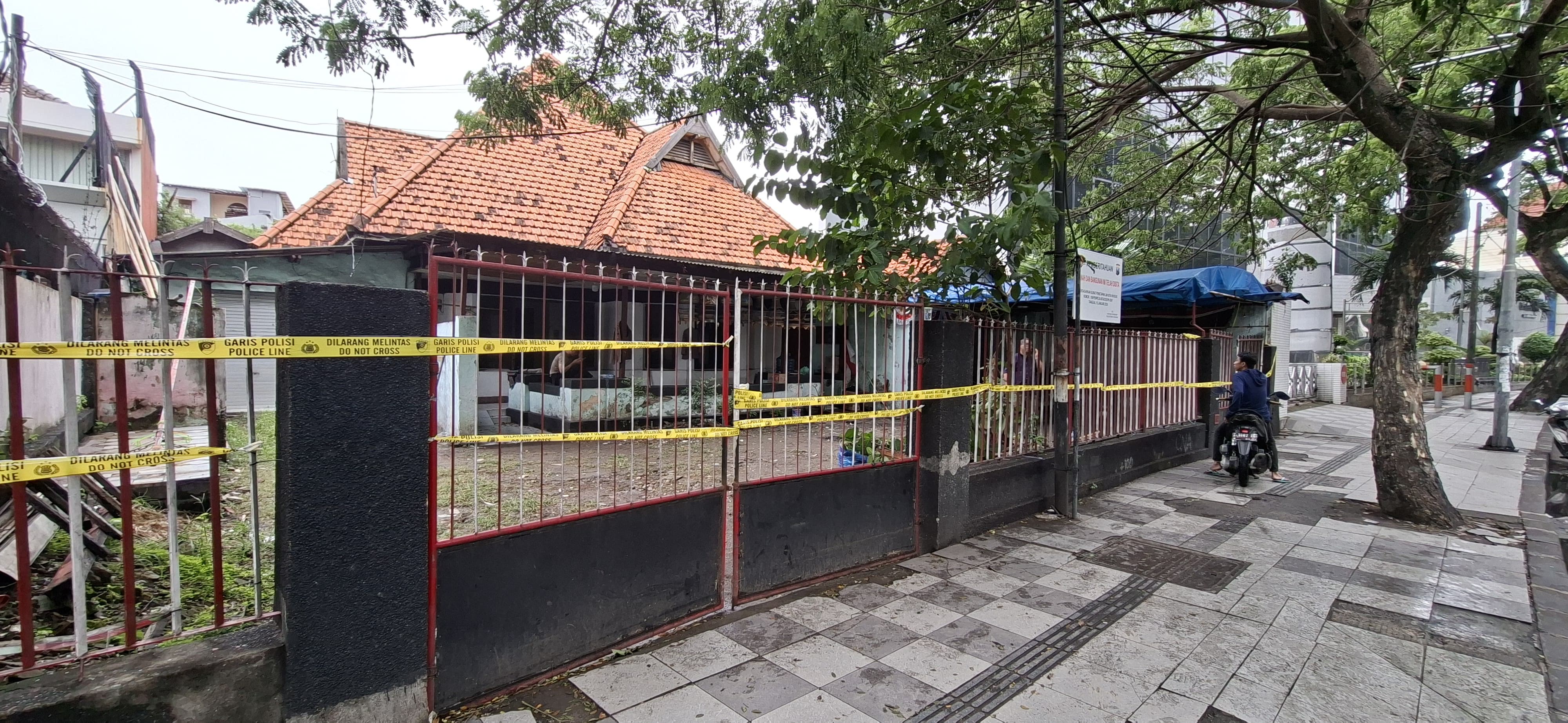 DILARANG MELINTAS: Kantor Madas di Jalan Darmo, Surabaya, dipasang garis polisi untuk proses penyelidikan dugaan pemalsuan dokumen.(MAHRUS/RADAR SURABAYA)