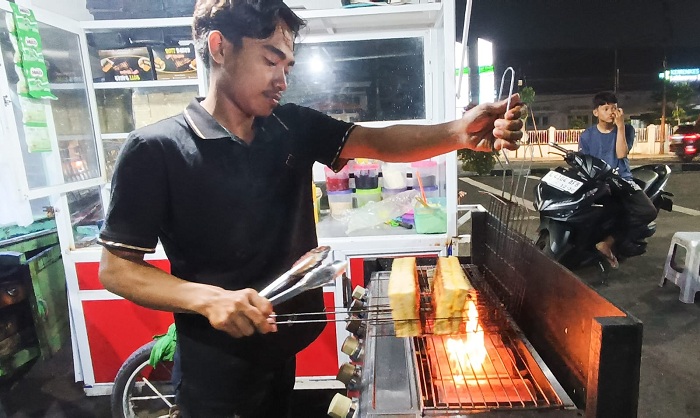 KREASI: Muhammad Badrul menyiapkan roti bakar pesanan pelanggannya yang menggunakan api secara langsung.