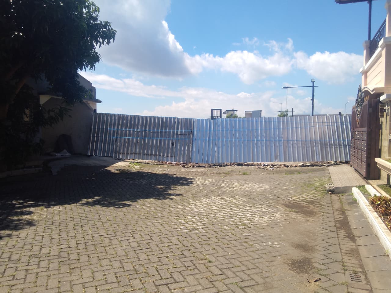 DITUTUP: Warga Mutiara Regency memasang pembatas darurat dari seng, dua hari pasca eksekusi pembongkaran tembok oleh Satpol PP.  (DIKY SANSIRI/RADAR SIDOARJO)