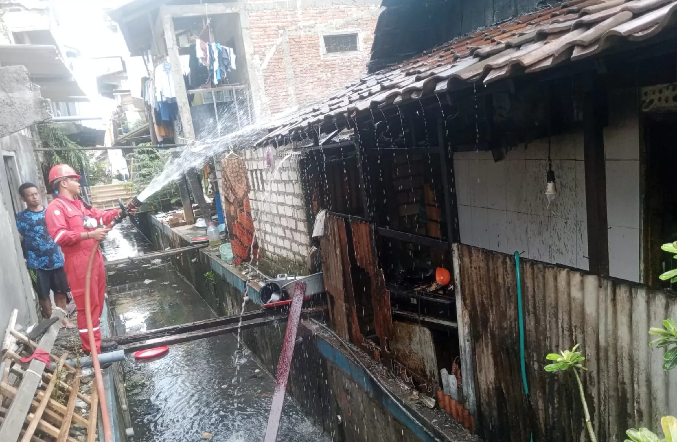 Petugas Damkar Kabupaten Gresik melakukan pemadaman kebakaran di rumah warga Jalan Gubernur Suryo Gg. 10 No. 14, RT 02 RW 05, Kecamatan Gresik.